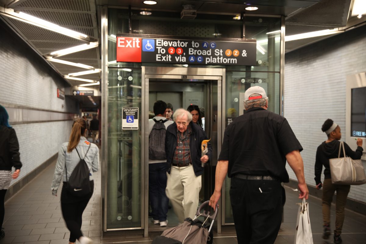 People entering and exiting subway elevator at a New York City Subway station