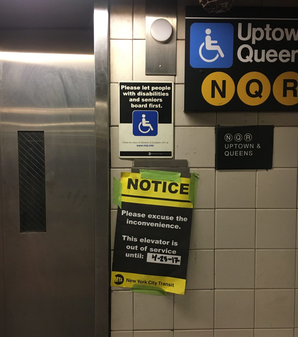 An out of service notice taped up outside a subway elevator.