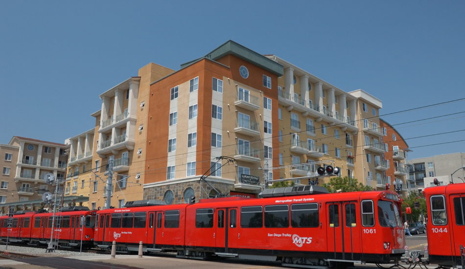 A red tram outside a beige building in San Diego