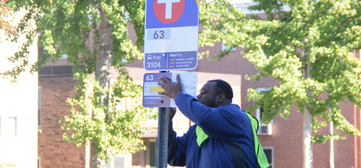 Metro transit worker installing a bus sign in Minneapolis