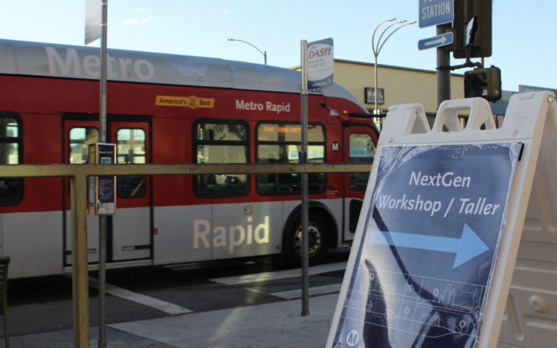 A bus stop with a sign for a NextGen bus network redesign public workshop