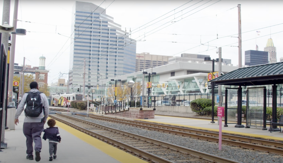 A caregiver and child walk through a Baltimore light rail station.